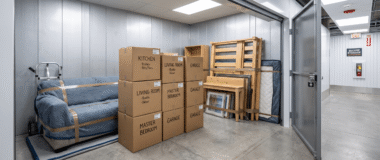 Storage for moving house Hoddesdon. Packed moving boxes, a sofa, and wrapped furniture neatly organized inside a secure Hoddesdon Self Storage unit during a house move